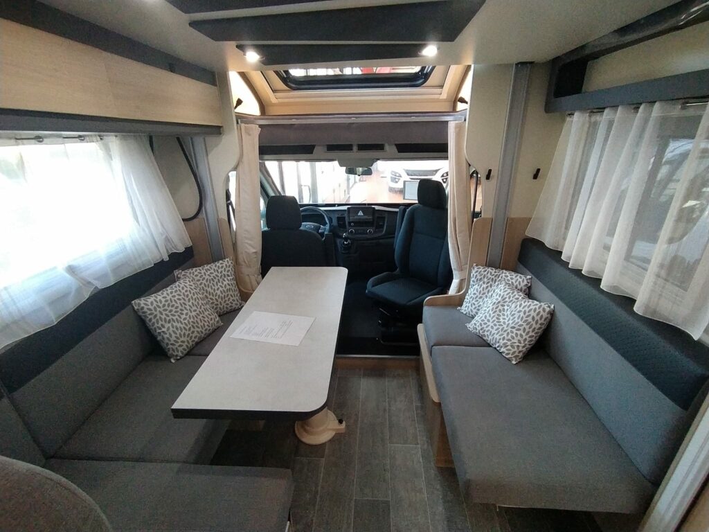 Interior de la autocaravana ITINEO PS700 2024, vista del salón hacia la cabina delantera