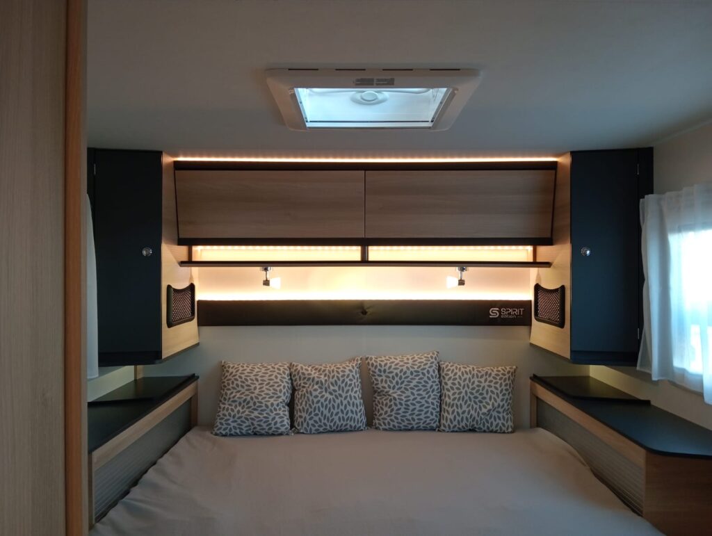 "Habitación principal de la Itineo MC 740 Spirit Edition con gran habitación, cama isla accesible por ambos lados, armarios de almacenamiento y claraboya para mayor luminosidad"