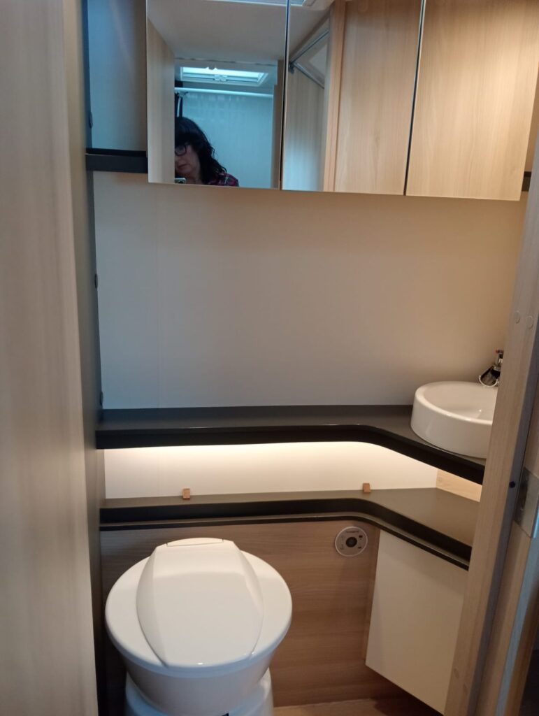 Baño espacioso en la Itineo MC 740 Spirit Edition con aseo separado, lavabo, espejo y armario de almacenamiento