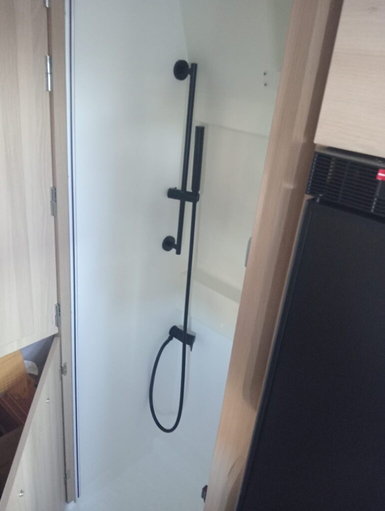 Ducha cómoda y amplia del Dreamer D55 Saphir Select con mampara, accesible tras abatir el armario del baño
