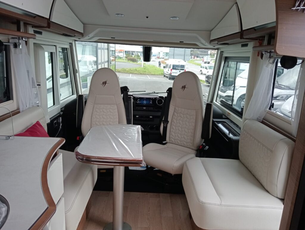 Salón face-to-face de la autocaravana Rapido I96M 2025 con mesa plegable laminada y moldura de madera maciza