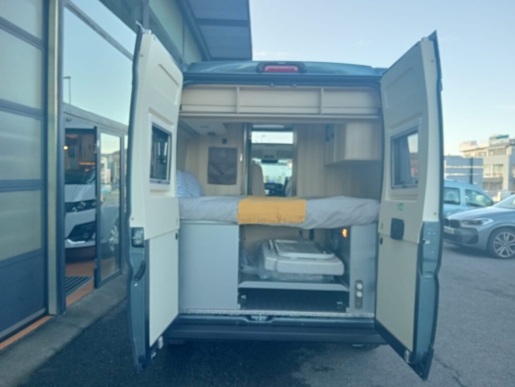 Cama transversal amplia de la Dreamer D55 Saphir Select con garaje trasero y dos ventanas equipadas con mosquitera y oscurecedor