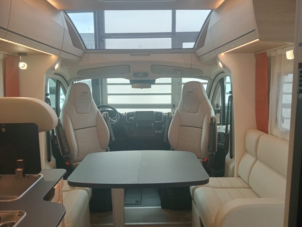 Salón de la autocaravana Rapido C86 Night Edition 2025 con mesa abierta y ventana de techo Sky Roof