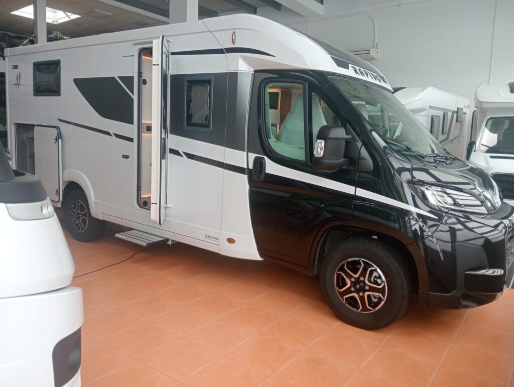 Autocaravana Rapido C86 Night Edition 2025 perfilada exterior vista desde el ángulo delantero derecho con puerta de entrada y garaje abiertos