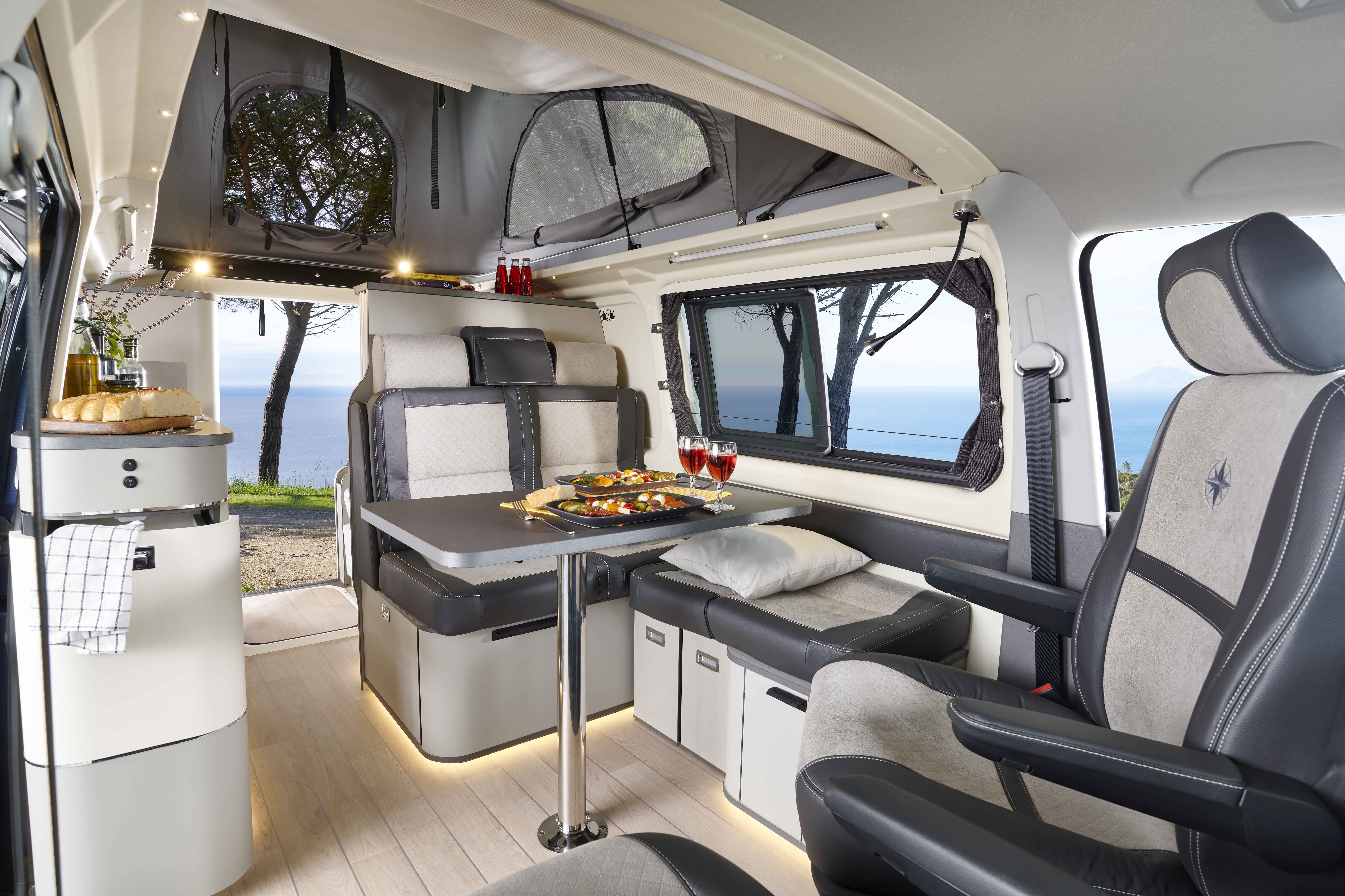 Interior de la camper Westfalia Kepler One con salón montado y techo elevable abierto