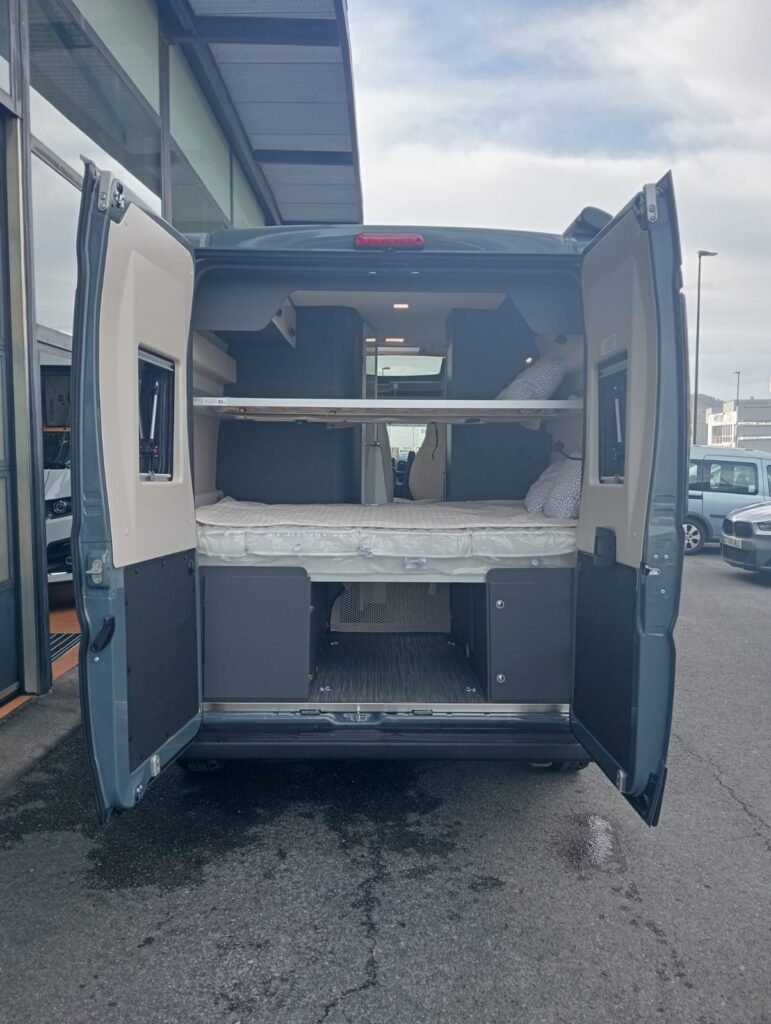 Zona trasera de la Mc Louis Menfys 3 Maxi con dos camas traseras tipo litera, portón con dos ventanas y garaje inferior bajo las camas